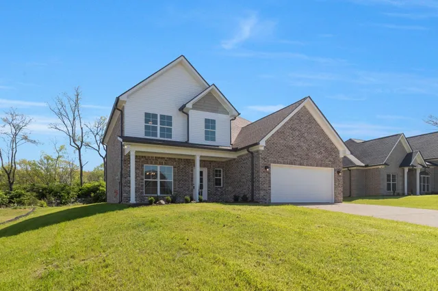 a view of a house with a yard and garage