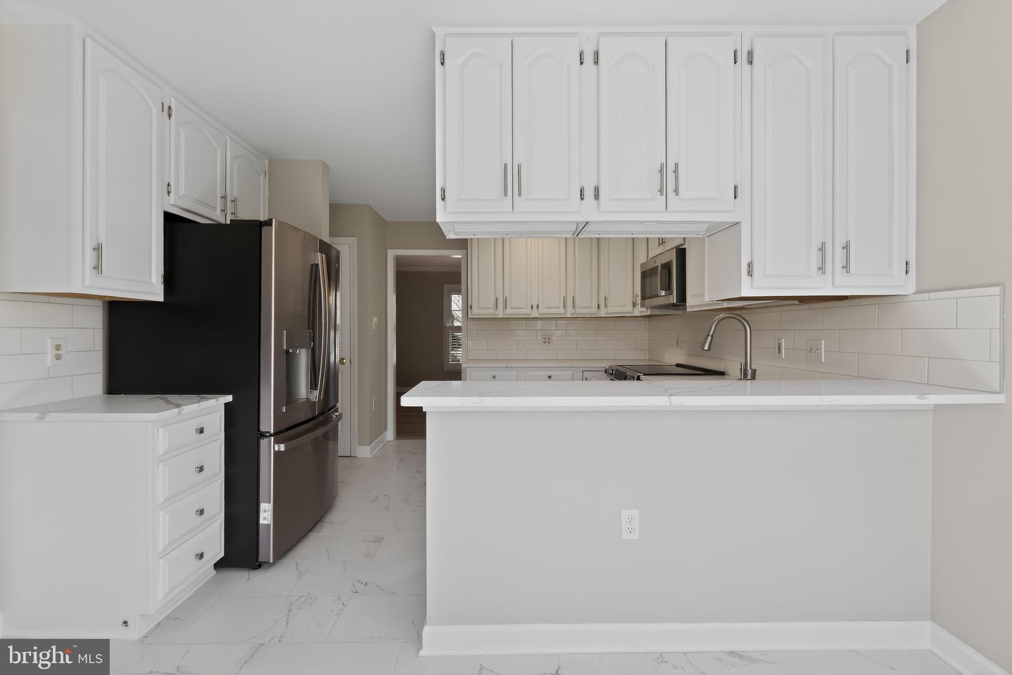 825 Dunbrooke Court Frederick, MD 21701 - Photo 13 of 31 a kitchen with stainless steel appliances granite countertop a refrigerator a stove a oven with white cabinets