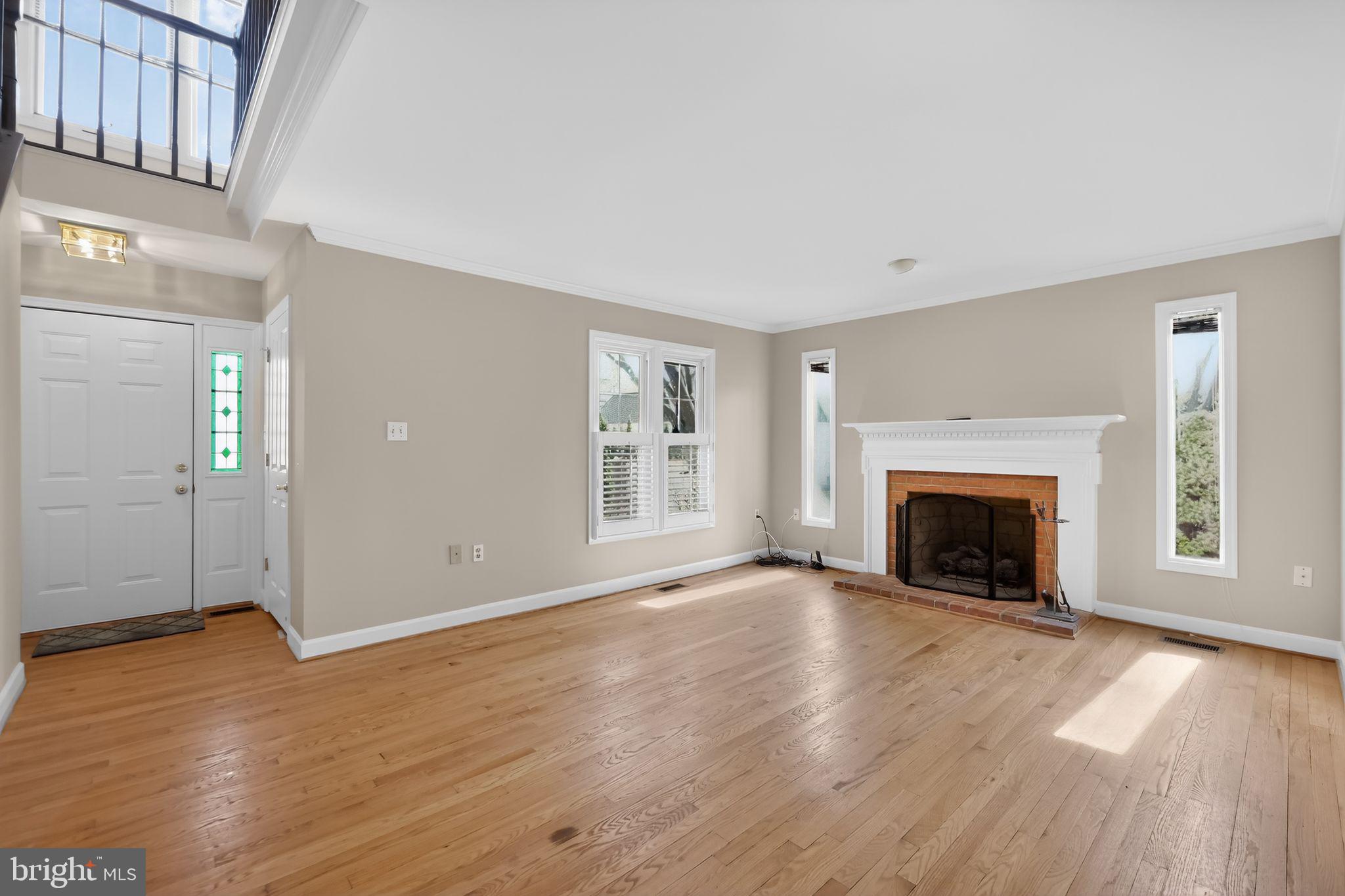 825 Dunbrooke Court Frederick, MD 21701 - Photo 7 of 31 an empty room with wooden floor fireplace and windows