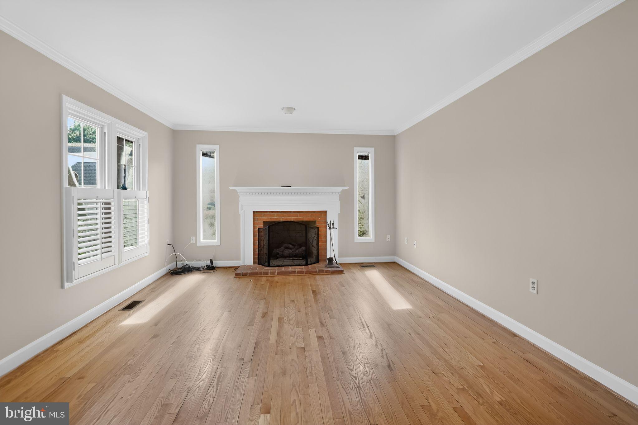 825 Dunbrooke Court Frederick, MD 21701 - Photo 8 of 31 an empty room with wooden floor fireplace and windows