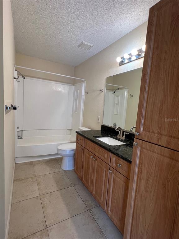 455 Alt 19, Unit 159 Palm Harbor, FL 34683 - Photo 15 of 26 a bathroom with a granite countertop sink a toilet mirror and a bathtub