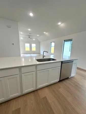 a kitchen with a sink cabinets and wooden floor