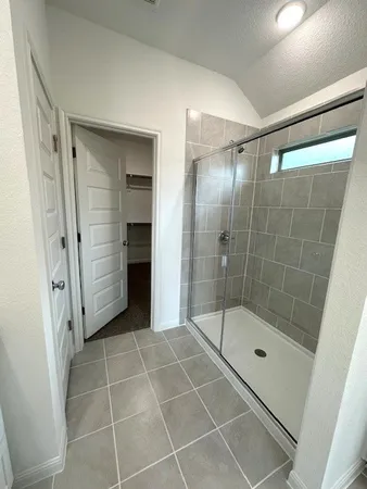 a bathroom with a glass shower door and a sink