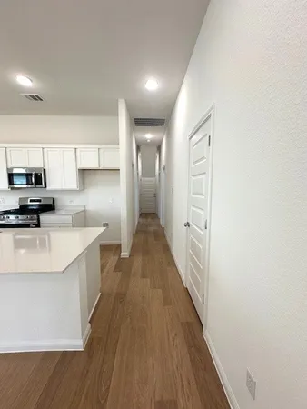 a white kitchen with wooden floor