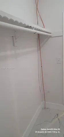 a kitchen with white cabinets and refrigerator