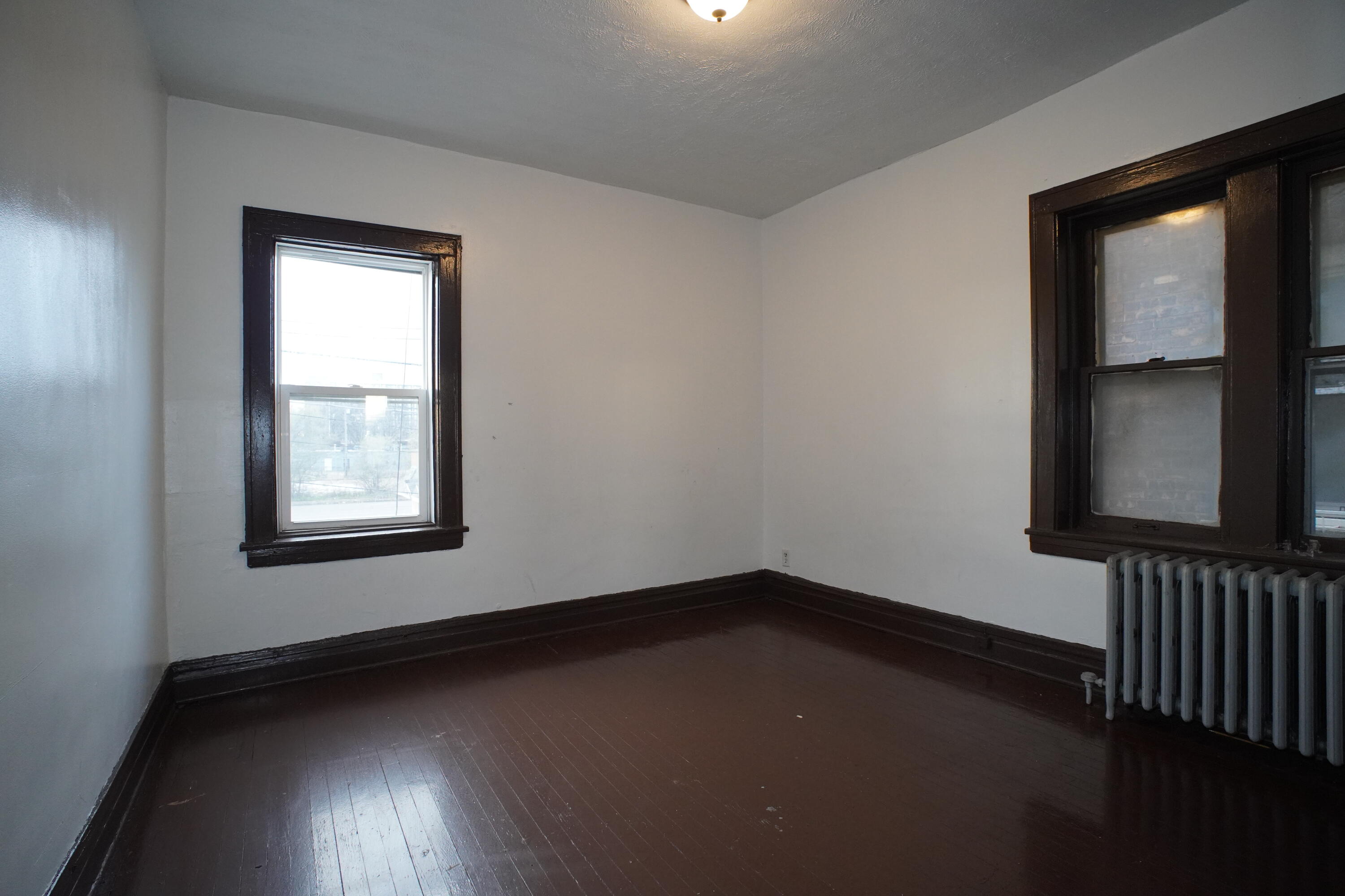 130 East 13th Avenue, Unit 8 Gary, IN 46407 - Photo 12 of 17 a view of an empty room with wooden floor and a window