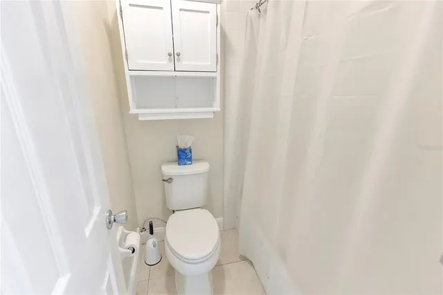 a white toilet sitting next to a shower curtain
