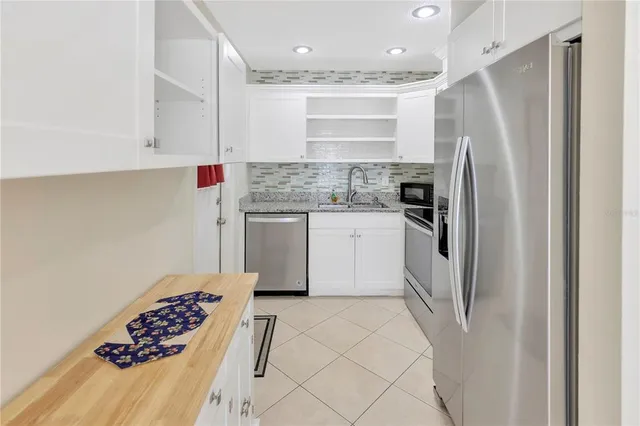 a kitchen with stainless steel appliances granite countertop a refrigerator and a sink