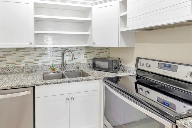 a kitchen with granite countertop a stove and a sink