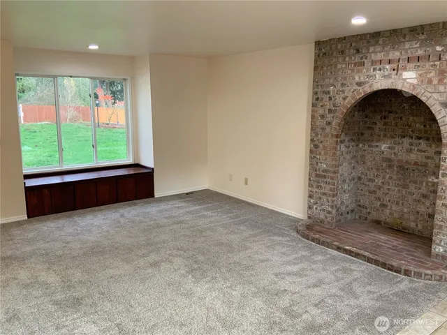 a view of empty room with a fireplace