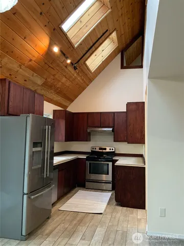 a kitchen with stainless steel appliances a refrigerator and a stove top oven