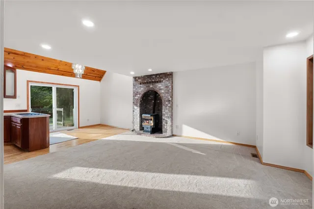a view of an empty room with a fireplace and a window