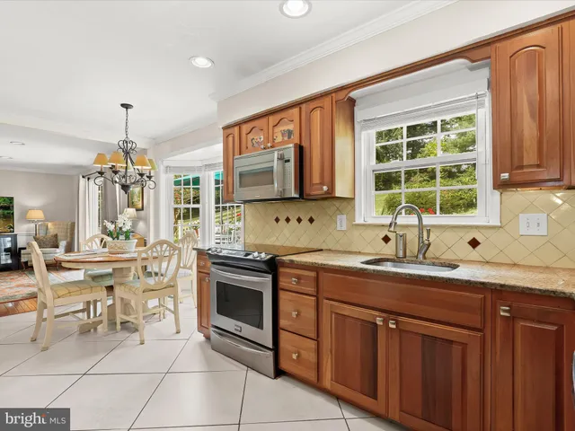 a dining room with furniture a chandelier and kitchen view