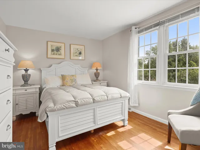 a spacious bedroom with a bed and chair