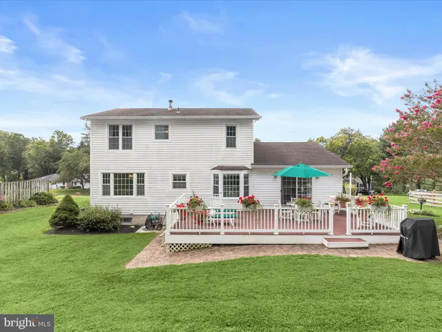 a front view of a house with garden and trees