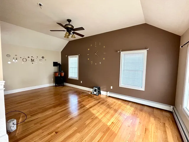 a view of an empty room with window and a ceiling fan