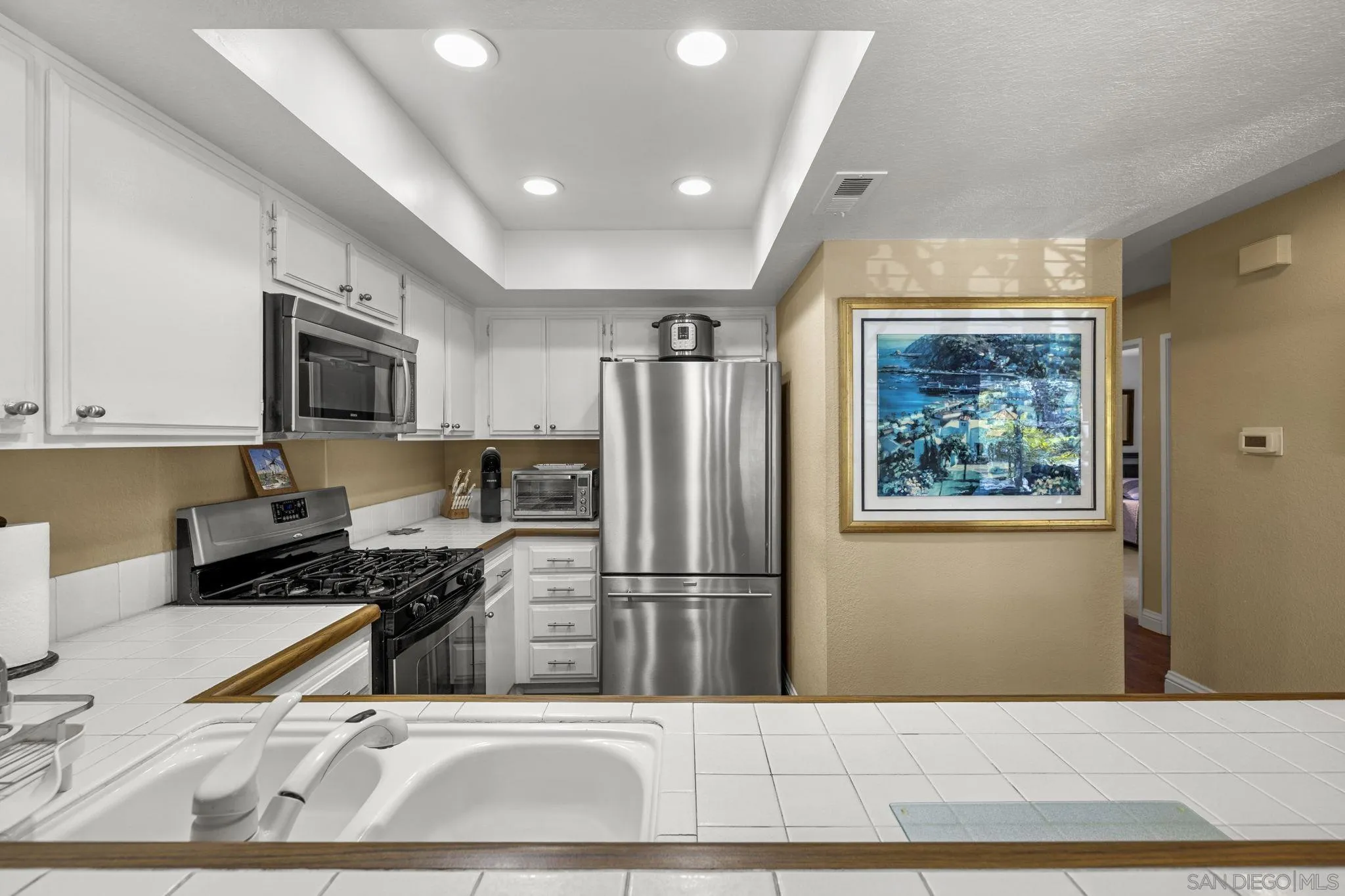883 Ginger Avenue Carlsbad, CA 92011 - Photo 11 of 33 a kitchen with stainless steel appliances granite countertop a refrigerator stove top oven and sink