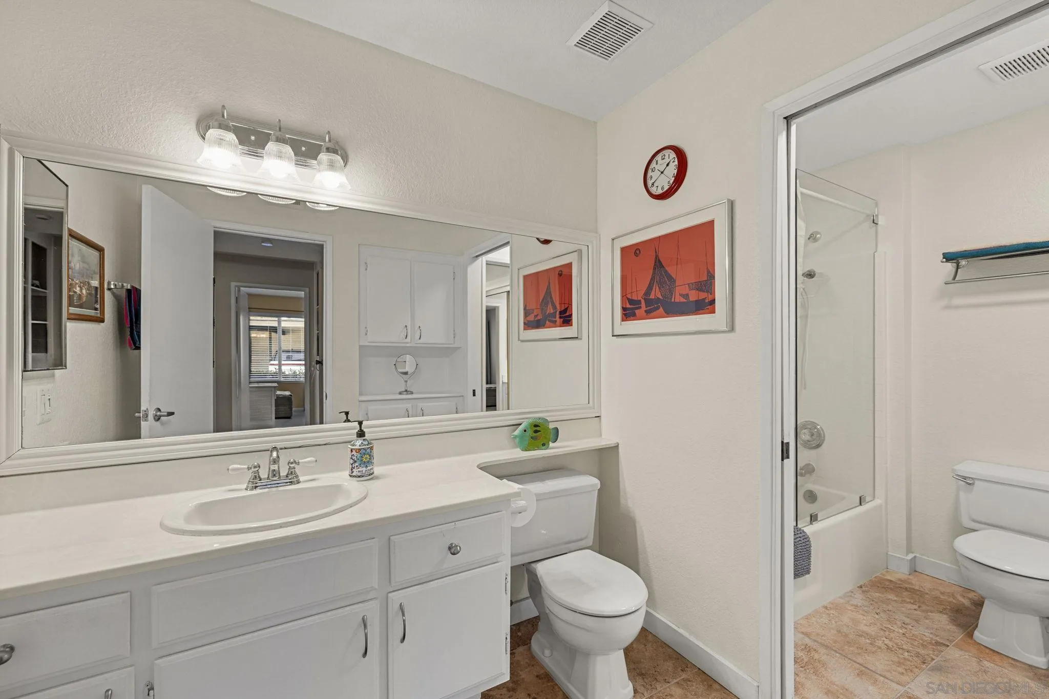 883 Ginger Avenue Carlsbad, CA 92011 - Photo 20 of 33 a bathroom with a sink a toilet a mirror and vanity