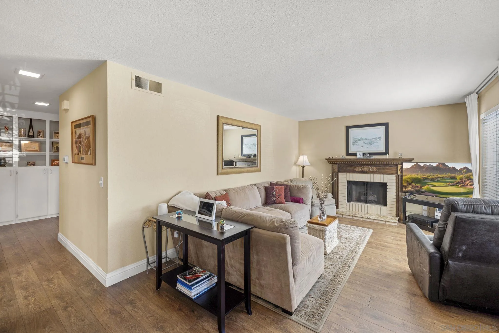 883 Ginger Avenue Carlsbad, CA 92011 - Photo 8 of 33 a living room with furniture a fireplace and a flat screen tv