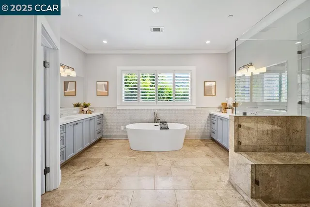 a bathroom with a tub sink mirror and window