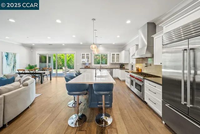 a kitchen with stainless steel appliances granite countertop a sink a stove and a refrigerator