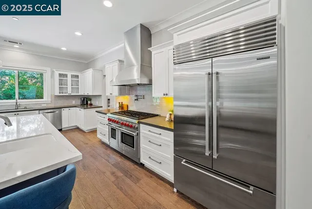 a kitchen with a refrigerator and white cabinets