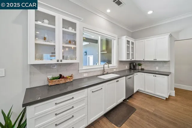 a kitchen with a sink window and cabinets
