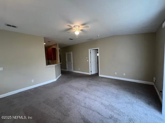 an empty room with a ceiling fan and window