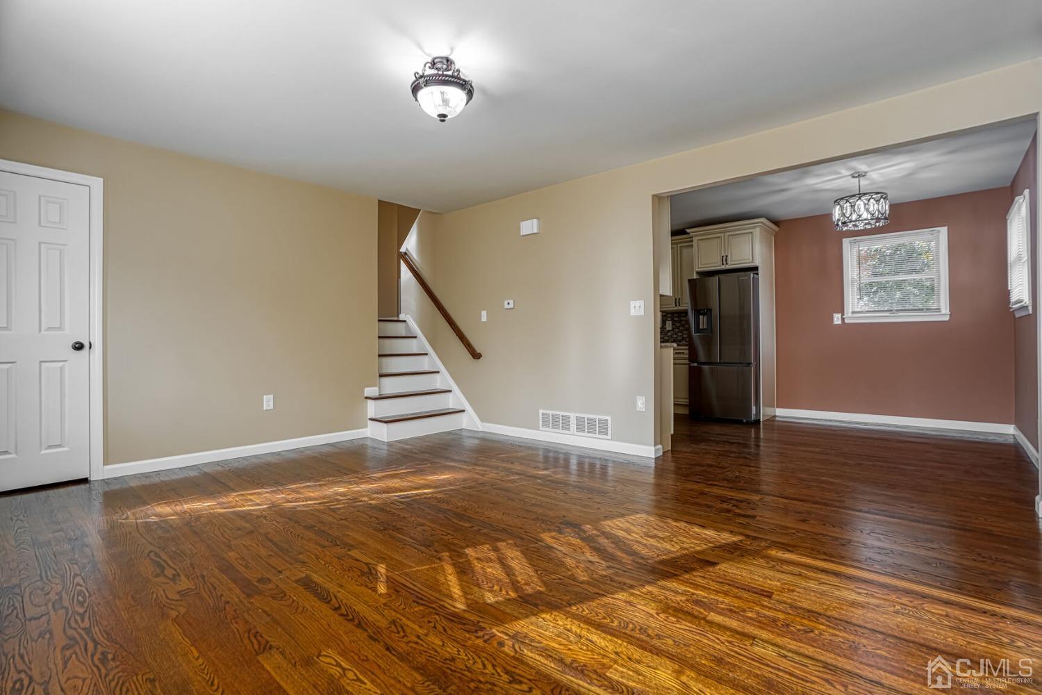245 McFarlane Road Colonia, NJ 07067 - Photo 4 of 25 a view of an empty room with wooden floor and a window