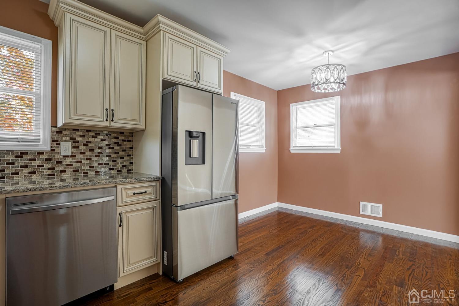 245 McFarlane Road Colonia, NJ 07067 - Photo 8 of 25 a kitchen with stainless steel appliances granite countertop a refrigerator a sink dishwasher a stove and white countertops with wooden floor