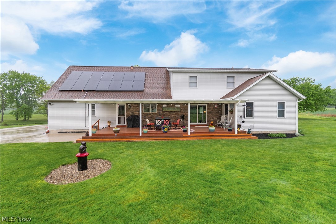 5212 Gray Road Ravenna, OH 44266 - Photo 29 of 37 Rear view of property with a wooden deck, solar panels, and a lawn
