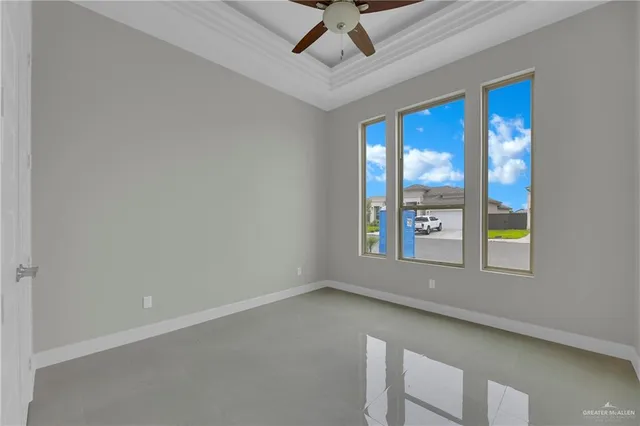 an empty room with windows and ceiling fan