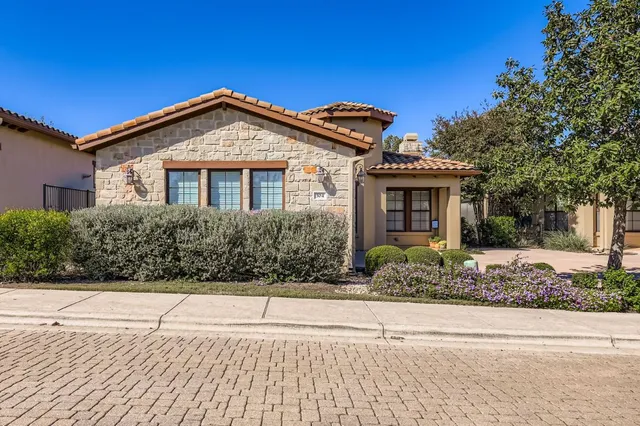 a front view of a house with a yard and potted plants