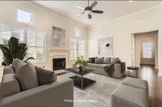 a living room with furniture a fireplace a flat screen tv and a large window