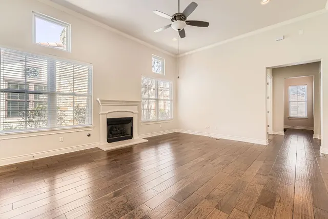 a view of a livingroom with a fireplace wooden floor and windows