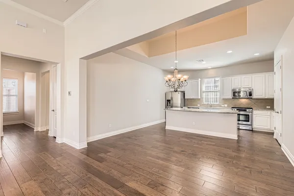 a large kitchen with cabinets and wooden floor