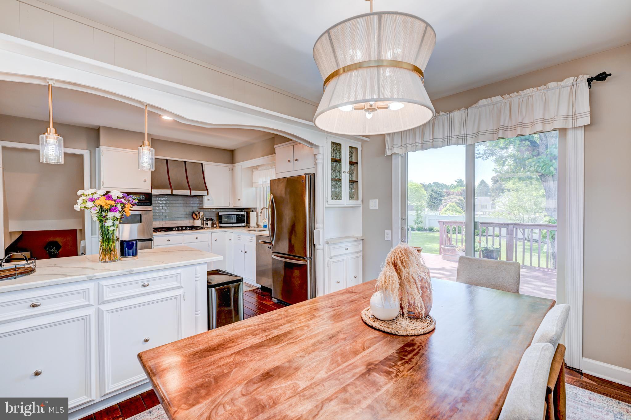 33 Dailey Drive Hamilton, NJ 08620 - Photo 8 of 27 a kitchen with stainless steel appliances granite countertop a refrigerator a stove a sink dishwasher a dining table and chairs with wooden floor
