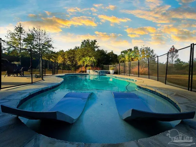 a view of a swimming pool with a yard and sitting area