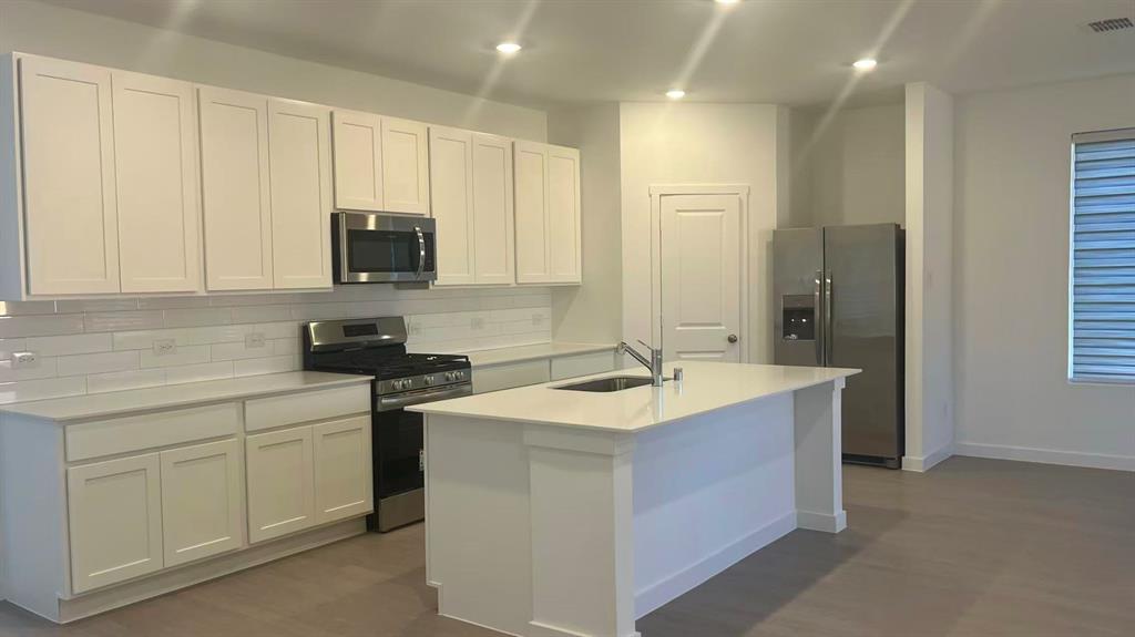 909 Calley Pear Trail Princeton, TX 75407 - Photo 8 of 17 a kitchen with a sink stove and cabinets