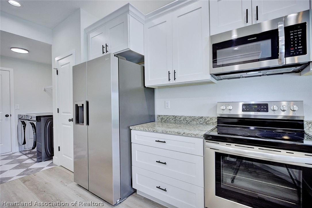 111 Vale Court Sebring, FL 33876 - Photo 15 of 40 a kitchen with granite countertop cabinets stainless steel appliances and a counter space