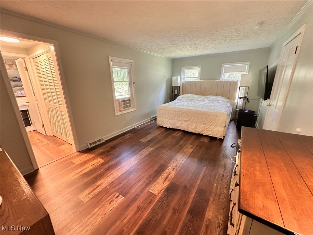 8145 Chagrin Road Chagrin Falls, OH 44023 - Photo 20 of 40 Bedroom with a closet, dark wood-style flooring, crown molding, and a textured ceiling
