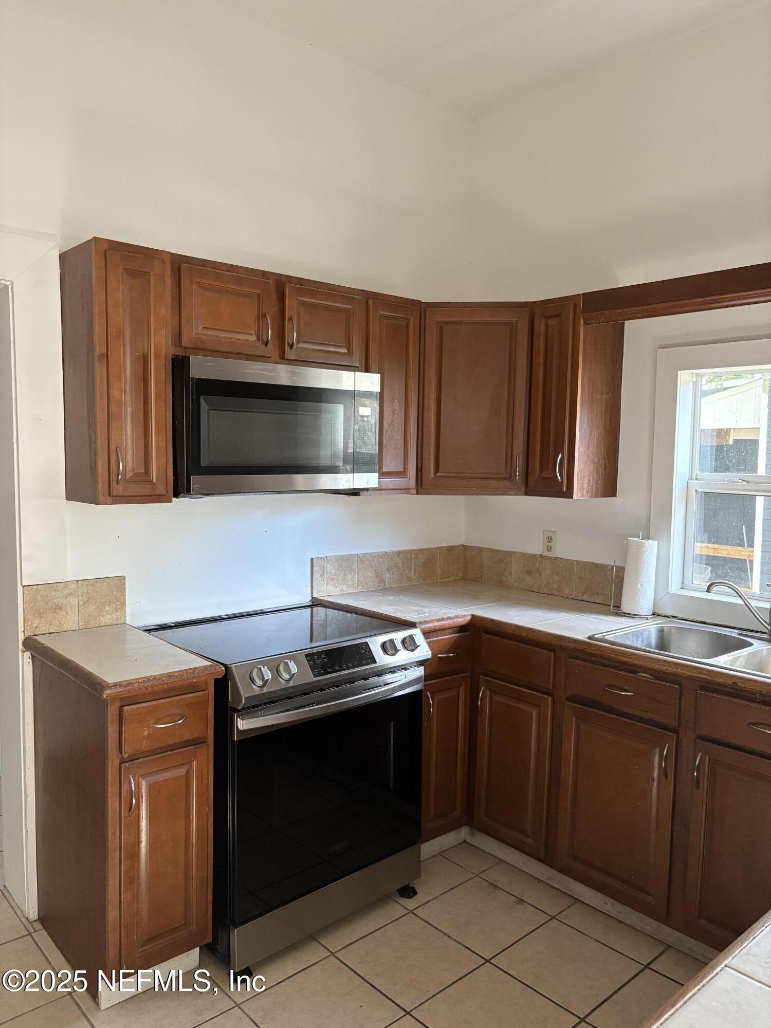 412 Madison Street Palatka, FL 32177 - Photo 13 of 29 a kitchen with stainless steel appliances a stove a sink and a microwave