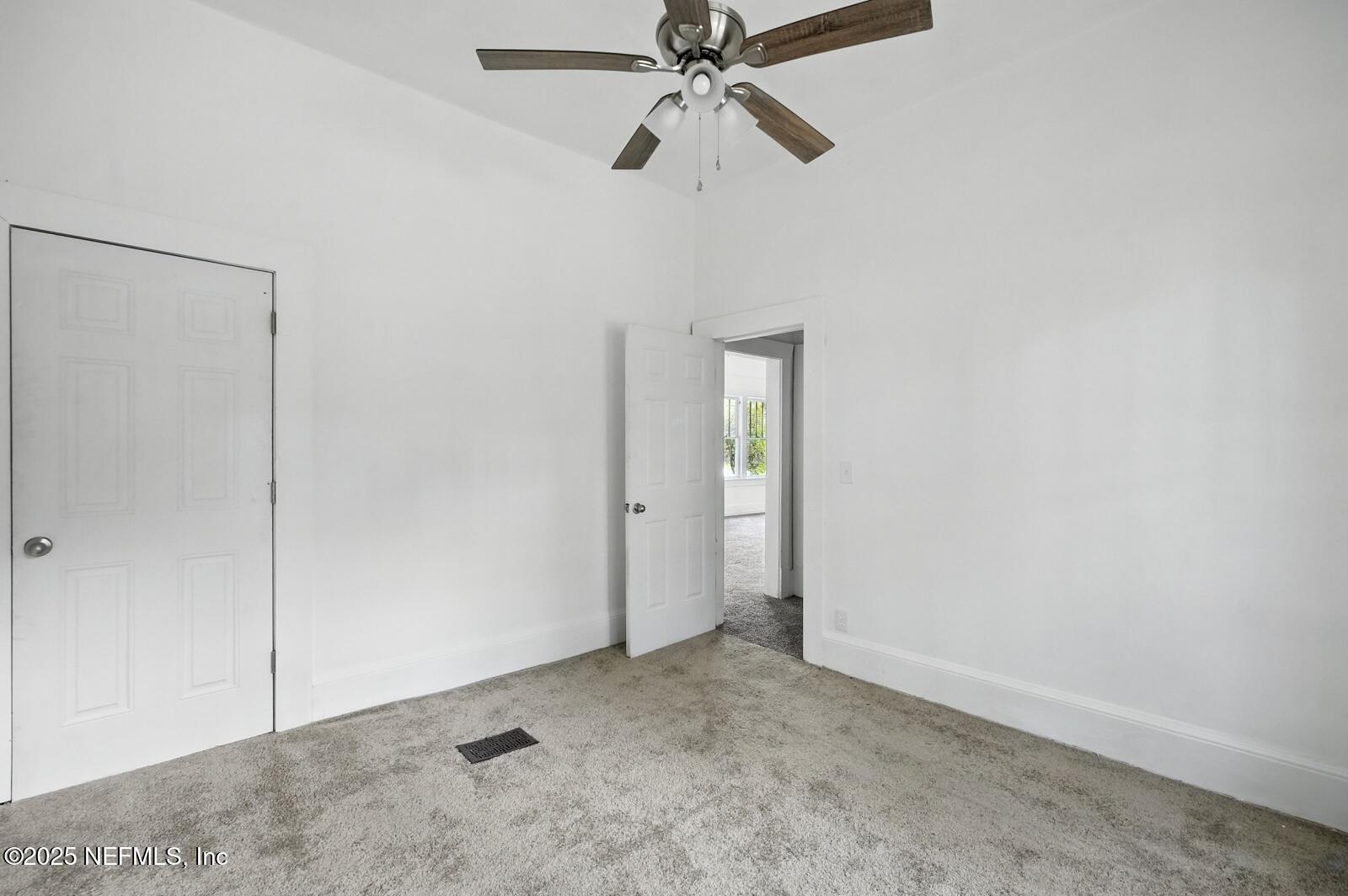412 Madison Street Palatka, FL 32177 - Photo 17 of 29 an empty room with closet and a chandelier fan