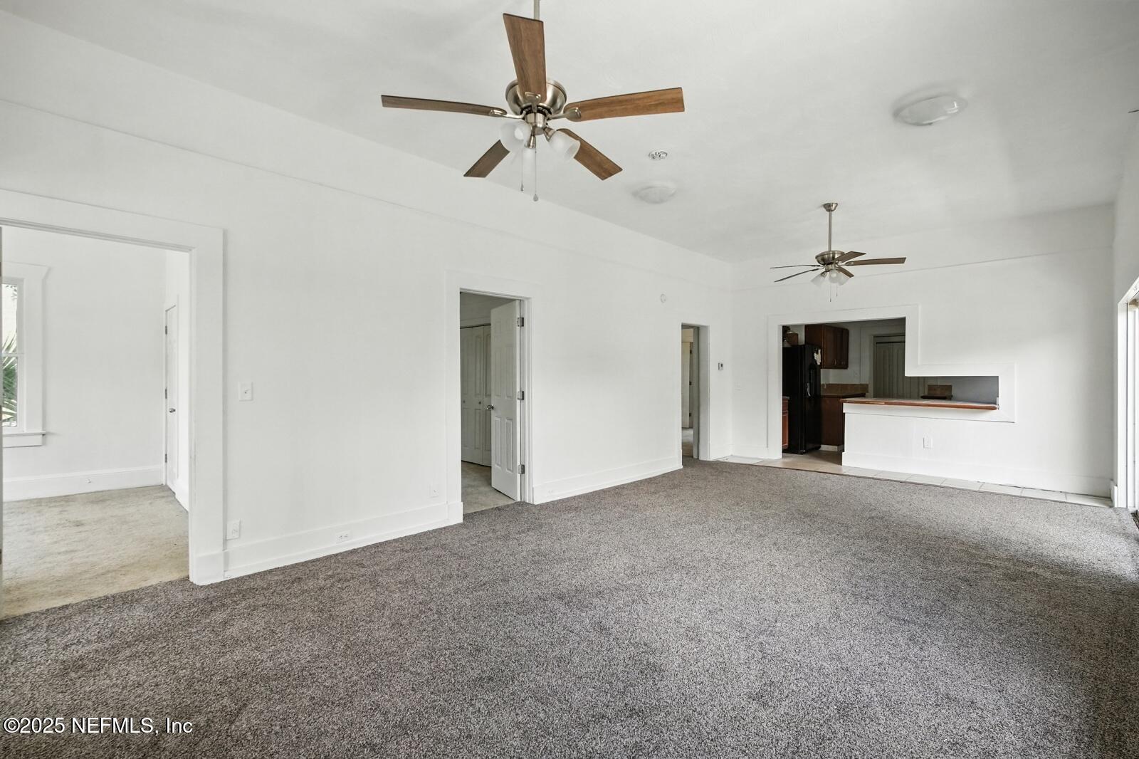 412 Madison Street Palatka, FL 32177 - Photo 9 of 29 a view of a livingroom with a ceiling fan a kitchen space with a sink and a ceiling fan
