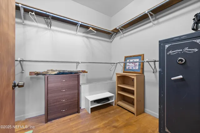 a bedroom with a bed and a flat tv screen on wall