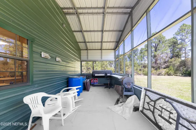an aerial view of residential house with outdoor space and trees all around