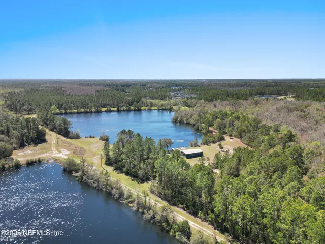 an aerial view of lake and residential houses with outdoor space