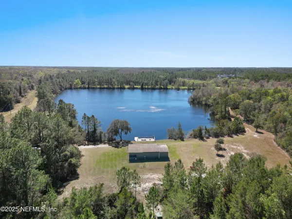 an aerial view of a house with a yard and lake view