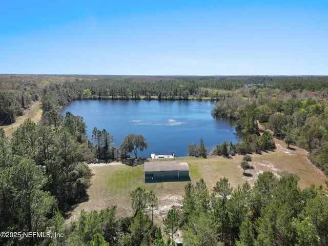 an aerial view of a house with a yard and lake view