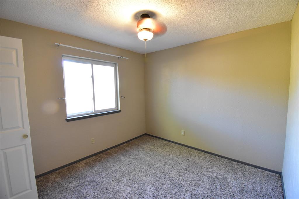 5414 Castleview Lane Garland, TX 75044 - Photo 11 of 20 Carpeted spare room with a textured ceiling and baseboards